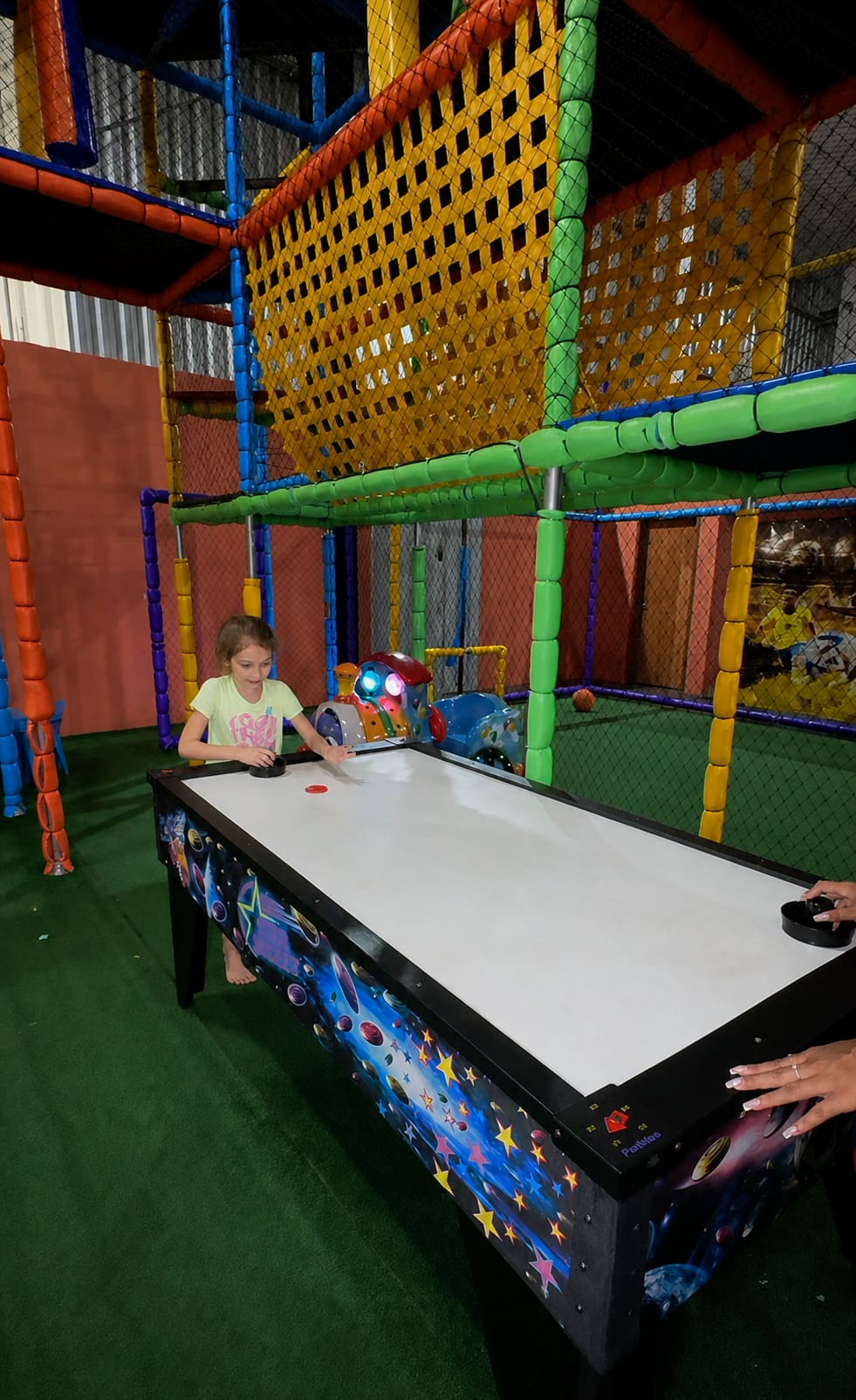 Criança brincando de air hockey no espaço kids da Italiamo Capicche Philadelpho